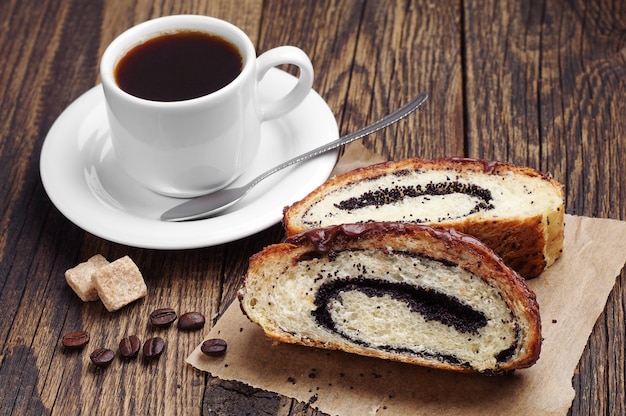 Kopje koffie en plak broodjes met papaver op houten tafel