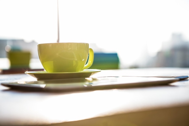 Kopje koffie en tablet pc op een bureau