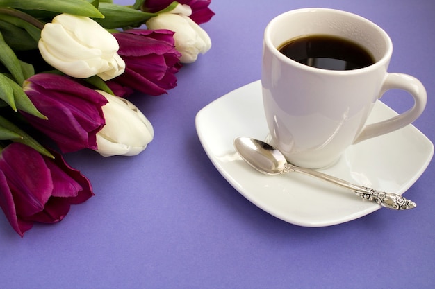 Kopje koffie en tulpen op de violette achtergrond