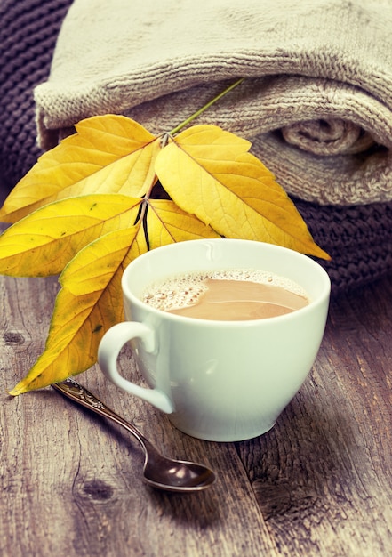 Kopje koffie en warme kleren op oude houten achtergrond