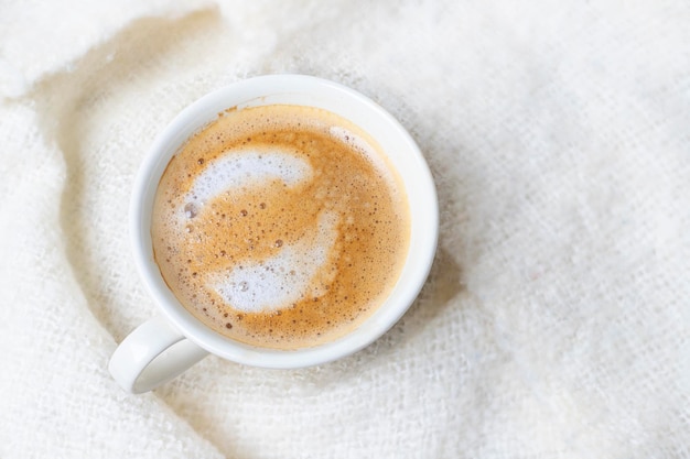 Kopje koffie in bed met deken van bovenaf gezien