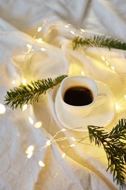 Kopje koffie in bed met een gerlandsnaald en licht