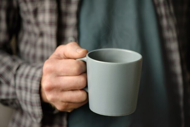 Kopje koffie in de hand van een man