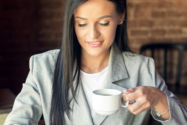 Kopje koffie in handen van de vrouw.