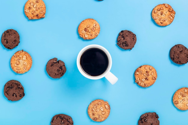 Kopje koffie, koekjes op een blauwe achtergrond. Bovenaanzicht, plat gelegd.