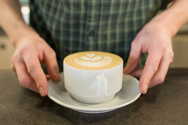 Kopje koffie kunst met de handen van mannelijke barista