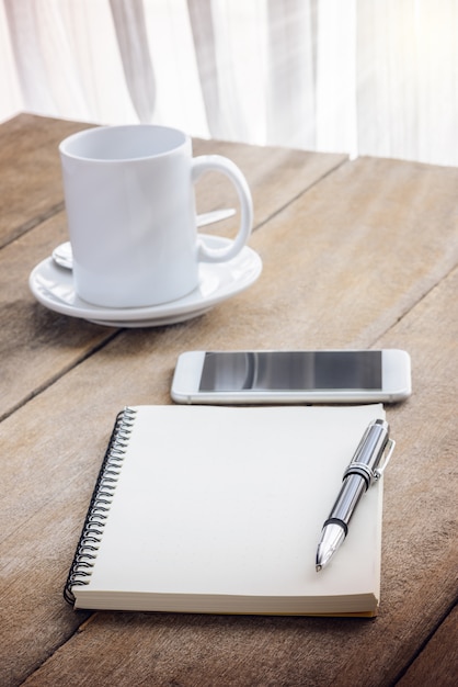 Kopje koffie, laptop, pen en slimme telefoon