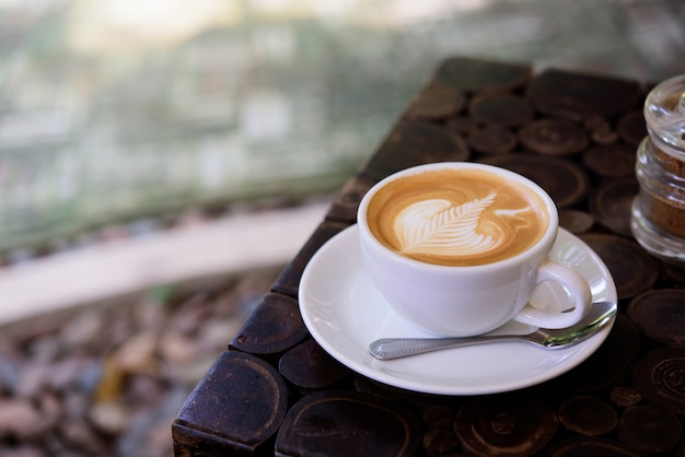 kopje koffie latte kunst op houten tafel.