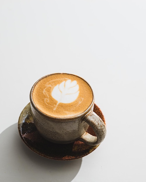 Kopje koffie latte op witte tafel in de coffeeshop in de ochtendtijd