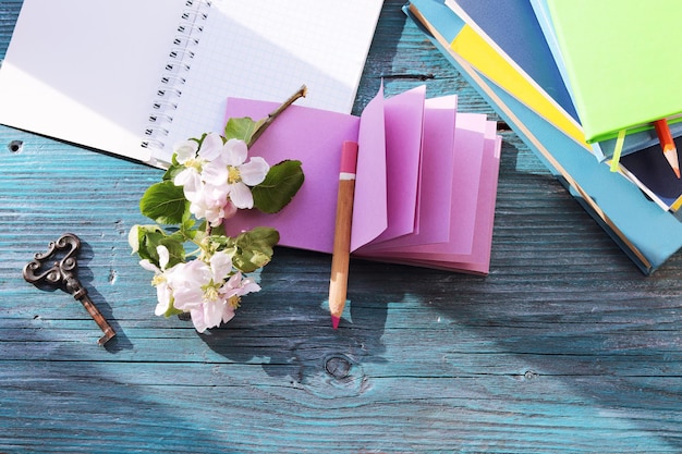 Kopje koffie lege notebook appelboom bloemen en een stapel boeken op een houten vensterbank