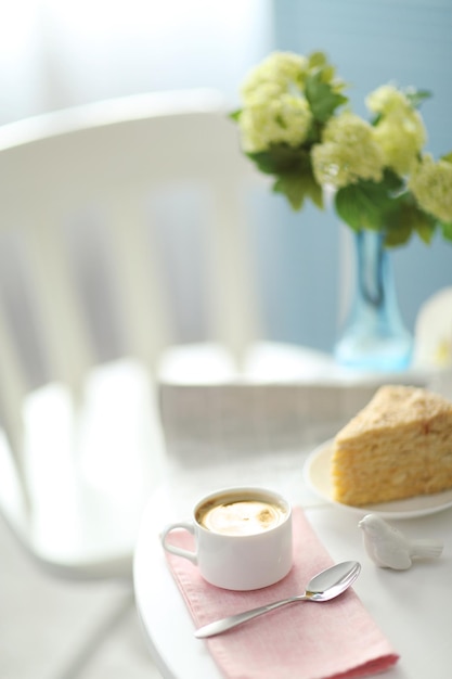 Kopje koffie met cake op witte tafel in licht interieur