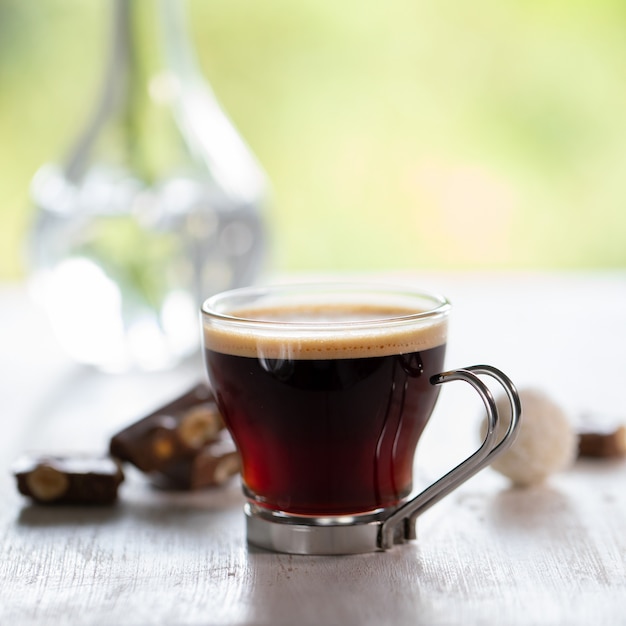 Kopje koffie met chocolade op witte houten tafel