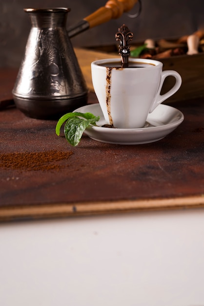 Kopje koffie met cooffee bonen met korrels van koffie en specerijen op een stenen achtergrond