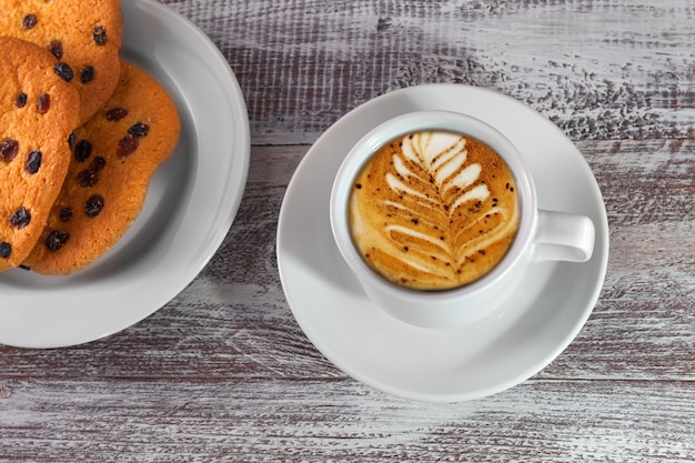 Kopje koffie met een dunne kapitein op een houten tafel