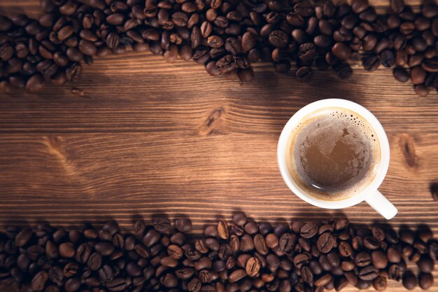 Kopje koffie met koffiebonen op de houten achtergrond