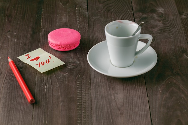 Kopje koffie met lippenstift merk en opmerking 'ik hou van je' op tafel close-up