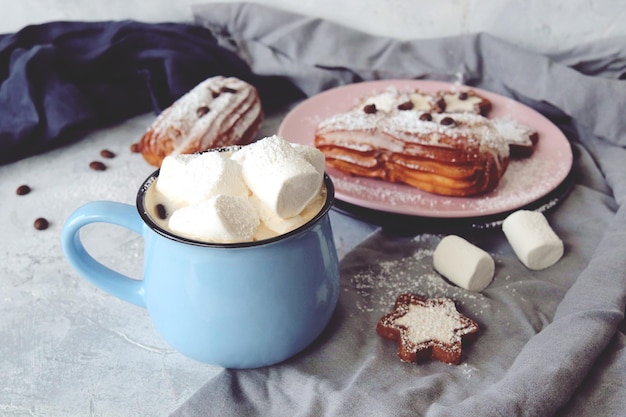 Kopje koffie met marshmallows eclairs en koekjes koffiebonen