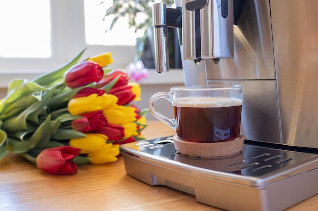 Kopje koffie met melk en tulpenbloemen aan