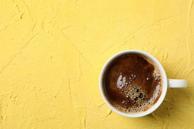 Kopje koffie met schuimige schuim op kleur achtergrond