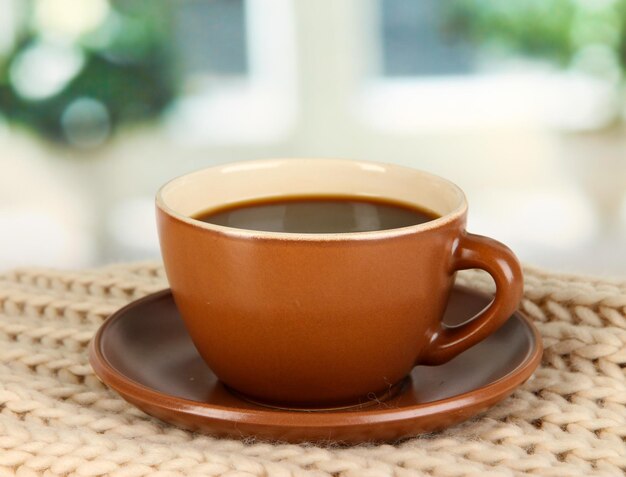 Kopje koffie met sjaal op tafel in de kamer