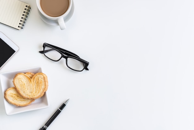 Kopje koffie met snacks en laptop op Bureau kantoor met kopie ruimte, bovenaanzicht