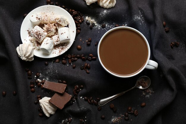 Foto kopje koffie met snoep op een zwart tafelkleed