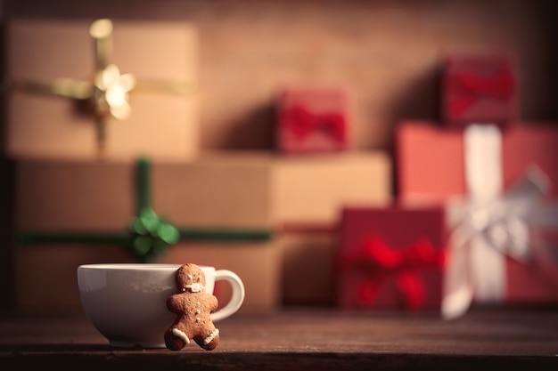 Kopje koffie met speculaaspop en kerstcadeau op houten tafel