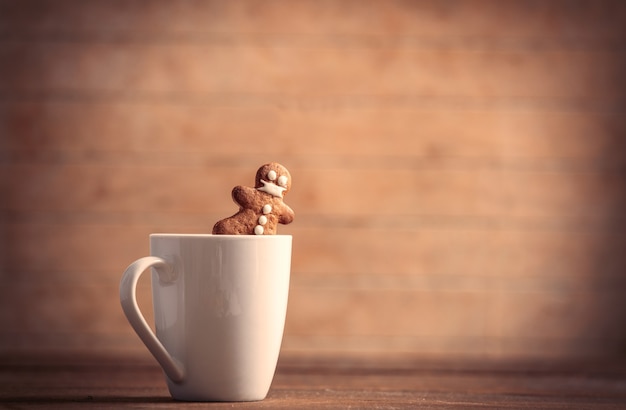 Kopje koffie met speculaaspop op houten tafel