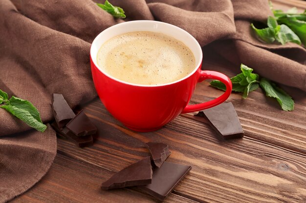 Kopje koffie met stukjes chocolade op tafel