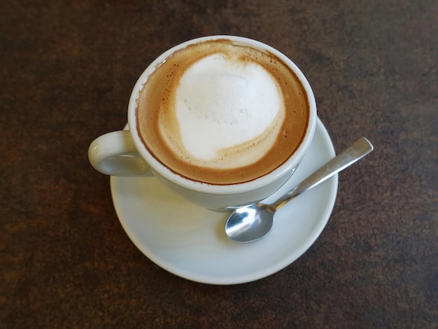 Kopje koffie met theelepel op tafel