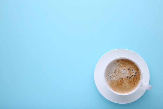 Kopje koffie op blauw, plat lag