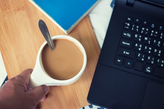 Kopje koffie op de houten laptop