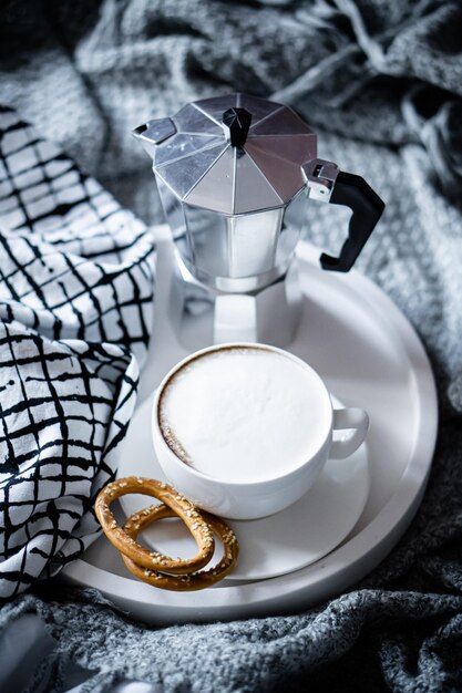 Kopje koffie op dienblad in gezellige winter slecht met wollen deken