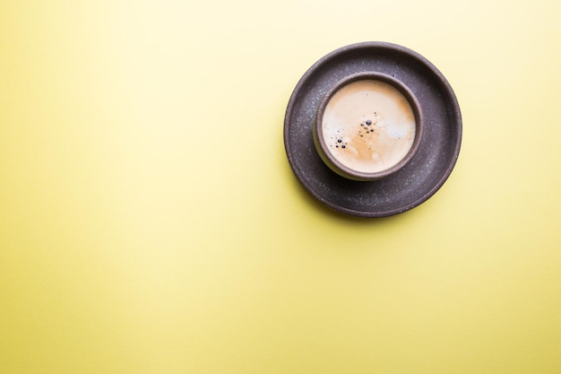 Kopje koffie op een kleurrijke gele achtergrond. bovenaanzicht met kopie ruimte. ochtend concept.