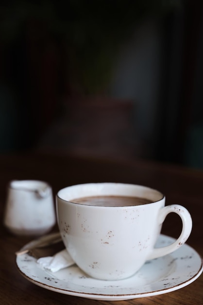 Kopje koffie op een tafel vintage kleurenfoto filmruis en graan in de foto Verticale frame selectieve focus wazig achtergrond Idee voor screensaver of menu-artikelen over koffie