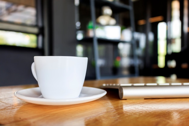 Kopje koffie op houten tafel met soft-focus op de achtergrond. over het licht