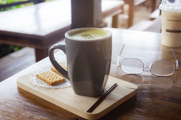 Kopje koffie op oude houten bureau. Eenvoudige werkruimte of koffiepauze in de ochtend