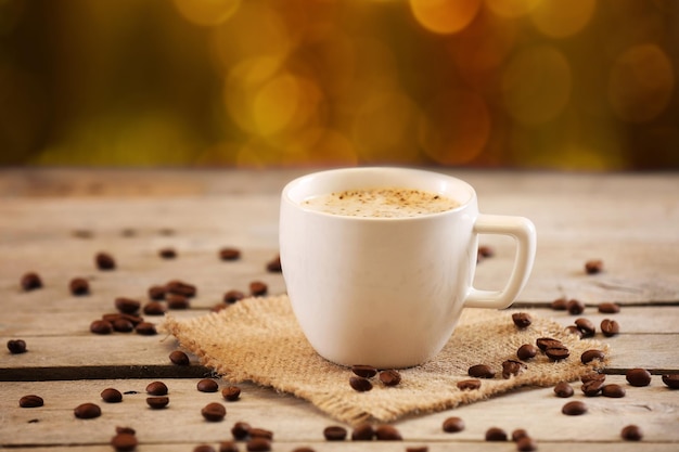 Kopje koffie op tafel op bruine achtergrond