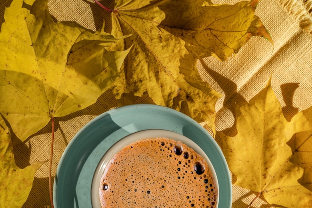 Kopje koffie over herfst geel, dakranden achtergrond.