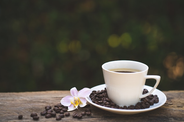 Kopje koffie, phaleanopsis op houten tafel.