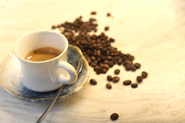 Kopje koffie tegen koffiebonen op houten tafel