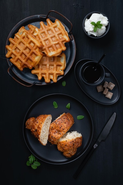 Kopje koffie wafel en croissant op houten zwarte tafel