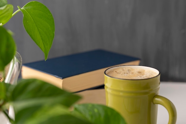 Kopje koffieplanten en boeken op een bureau