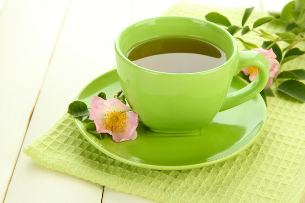 Kopje kruidenthee met hippe roze bloemen op witte houten tafel