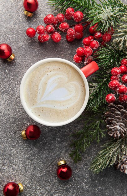 Kopje latte koffie en kerstversiering op een donkere betonnen achtergrond