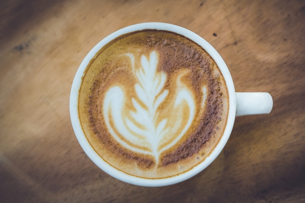 kopje latte koffie op houten tafel, donkere toon