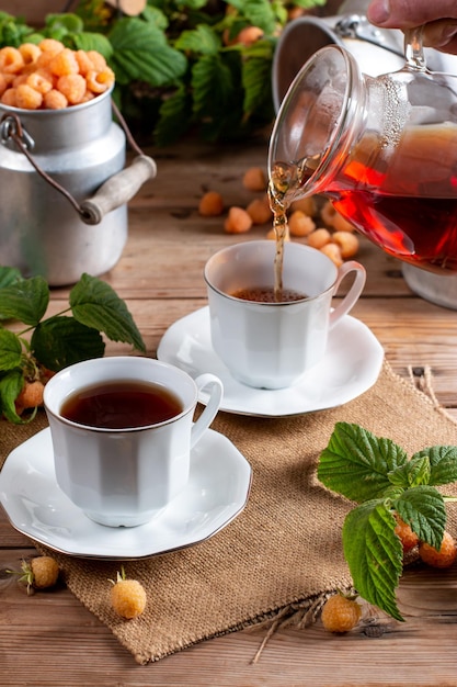 Kopje lekkere frambozenthee op houten tafel Nuttig drankje voor de gezondheid Kruidenthee Traditionele geneeskunde