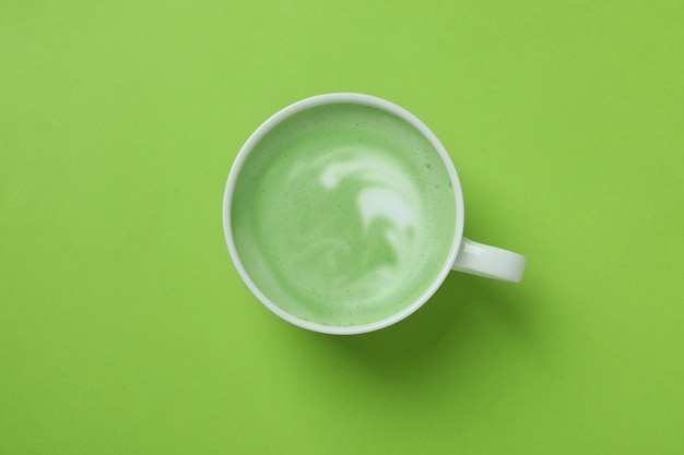 Kopje matcha latte op groene achtergrond