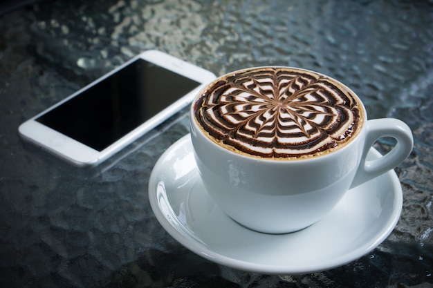 Kopje mokka koffie op tafel met smartphone