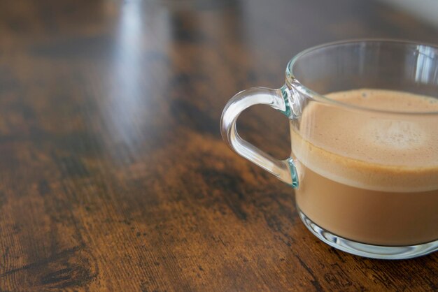 Kopje sprankelende Dolce Gusto latte koffie op houten tafel